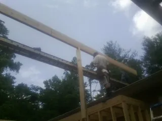 Carpenter setting a ridge beam over a new addition frame — Ice Dam Removal by Roofing Brothers in Ranger