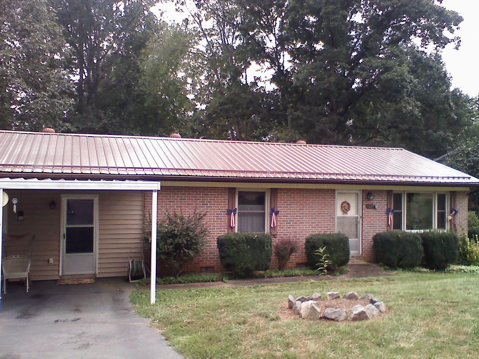 Bronze metal roof and carport on a brick ranch home — Roof Repair work by our crew in Ranger